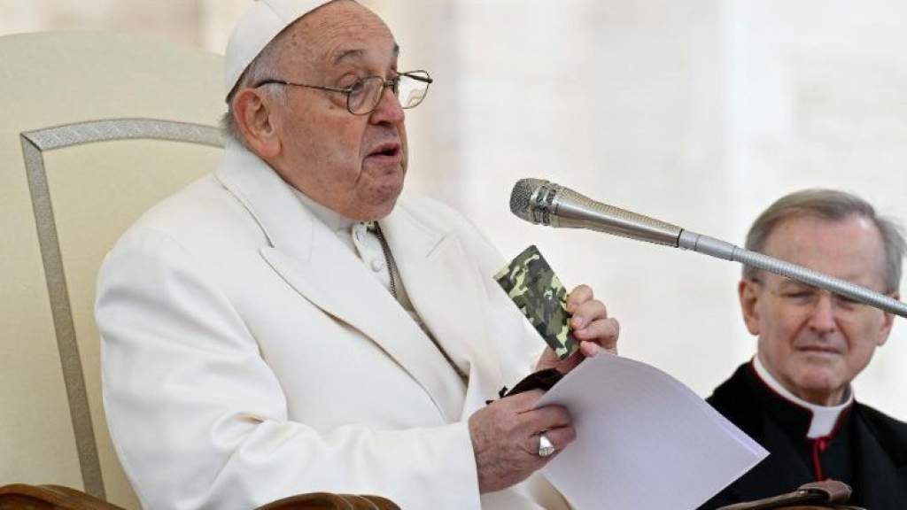 Ferenc pápa az asztalán tartja egy elesett ukrán katona bibliáját